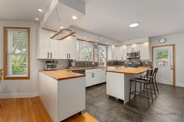 2800 Auxplaines Ave, River Grove, IL 60171 - kitchen with butcher block counters, stainless steel appliances, healthy amount of natural light, tasteful backsplash, and recessed lighting