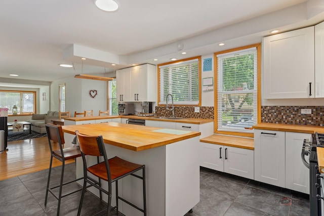 2800 Auxplaines Ave, River Grove, IL 60171 - kitchen with butcher block countertops, a kitchen breakfast bar, recessed lighting, white cabinetry, and gas stove