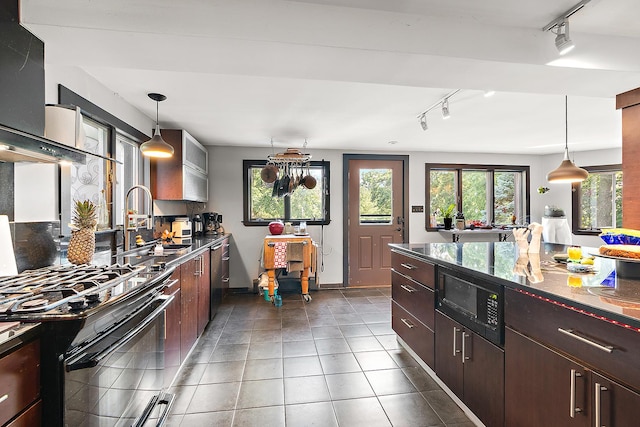 1108 Plaza Dr, New Lenox, IL 60451 - kitchen with track lighting, black gas range oven, tile patterned flooring, hanging light fixtures, and wall chimney exhaust hood