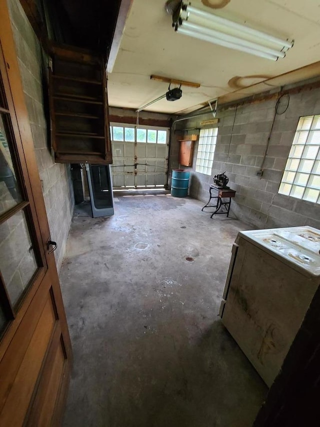 garage featuring a garage door opener, concrete block wall, and french doors