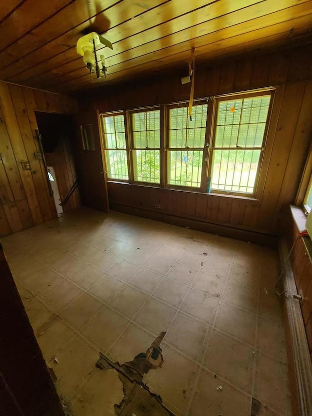 spare room with light flooring and wooden walls