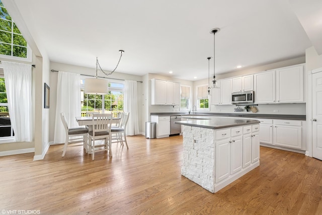 1755 Goldsboro Ln, Crystal Lake, IL 60014 - kitchen with appliances with stainless steel finishes, dark countertops, a center island, white cabinets, and light wood-style floors