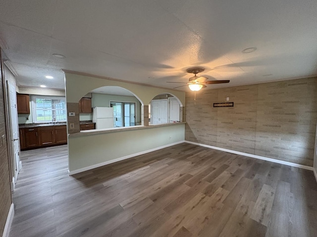 11071 E Fisher Rd, Rochelle, IL 60168 - unfurnished living room with wood finished floors, ceiling fan, and arched walkways