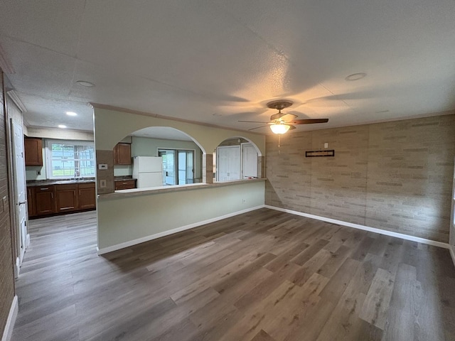 11071 E Fisher Rd, Rochelle, IL 60168 - unfurnished living room with wood finished floors, a ceiling fan, and arched walkways