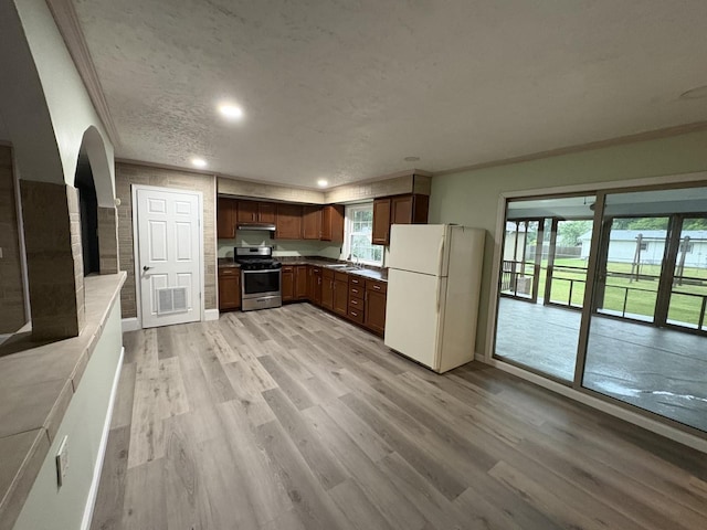 11071 E Fisher Rd, Rochelle, IL 60168 - kitchen with freestanding refrigerator, stainless steel gas stove, under cabinet range hood, light wood-type flooring, and recessed lighting