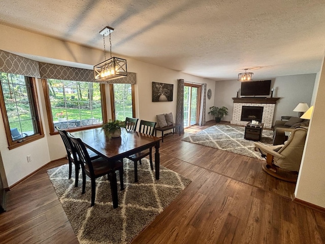120 Colebrook Pl, Rockton, IL 61072 - dining room with a textured ceiling, dark wood-style flooring, a fireplace, and a chandelier