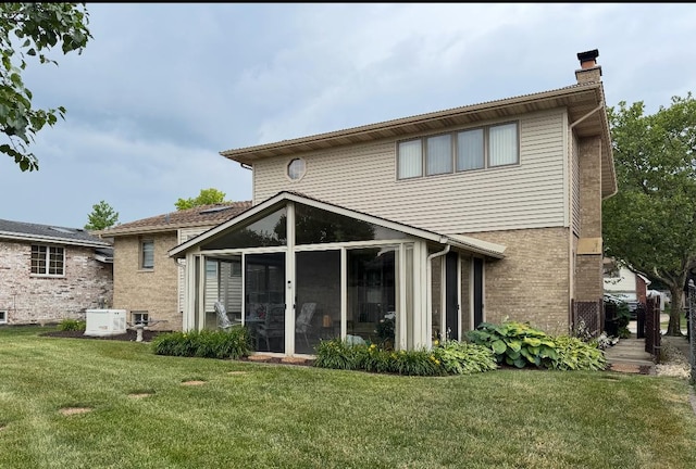 17081 Bonnie Trl W, Oak Forest, IL 60452 - rear view of house with a chimney, a sunroom, a lawn, and brick siding