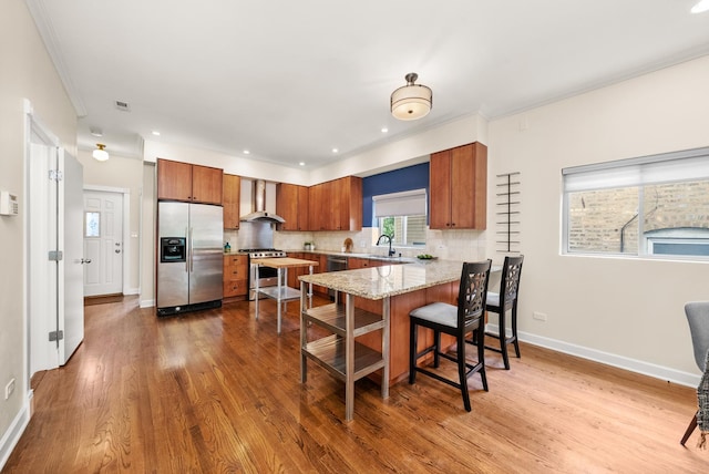 2031 W Saint Paul Ave Unit 2W, Chicago, IL 60647 - kitchen with appliances with stainless steel finishes, brown cabinetry, a peninsula, wood finished floors, and recessed lighting