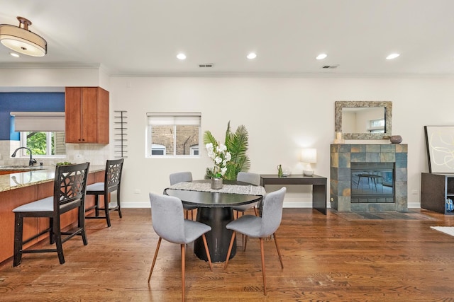 2031 W Saint Paul Ave Unit 2W, Chicago, IL 60647 - dining room featuring crown molding, recessed lighting, a tile fireplace, and wood finished floors