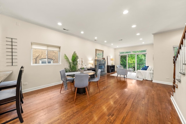 2031 W Saint Paul Ave Unit 2W, Chicago, IL 60647 - dining space featuring crown molding, stairs, wood finished floors, recessed lighting, and a tile fireplace