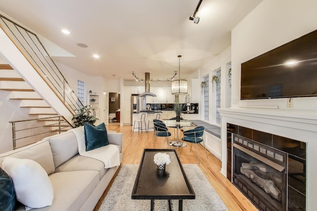2145 W Crystal St Unit 1, Chicago, IL 60622 - living room featuring stairs, a tiled fireplace, light wood finished floors, and recessed lighting