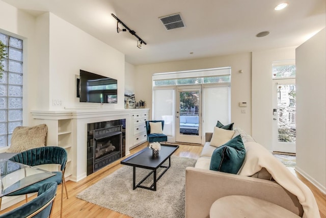 2145 W Crystal St Unit 1, Chicago, IL 60622 - living area featuring a tiled fireplace, wood finished floors, rail lighting, and recessed lighting
