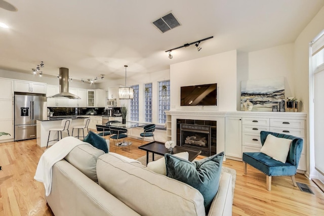 2145 W Crystal St Unit 1, Chicago, IL 60622 - living room with rail lighting, light wood-style flooring, and a fireplace