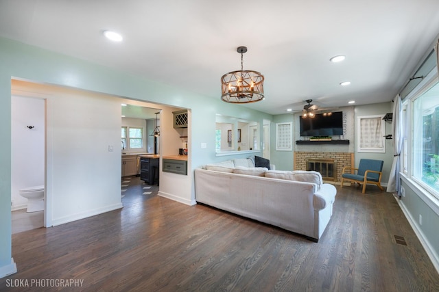 531 Rockland Rd, Crystal Lake, IL 60014 - living area with a brick fireplace, dark wood-style flooring, a chandelier, a ceiling fan, and recessed lighting