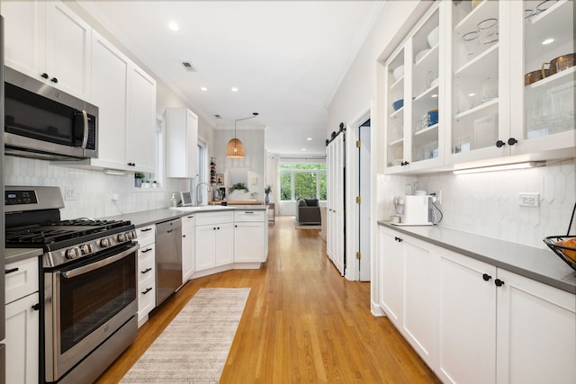 3316 N Leavitt St Unit 2, Chicago, IL 60618 - kitchen with appliances with stainless steel finishes, light wood-type flooring, white cabinetry, decorative backsplash, and open floor plan