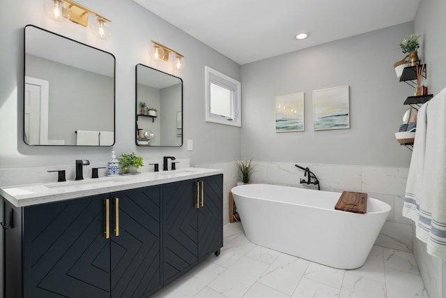 3316 N Leavitt St Unit 2, Chicago, IL 60618 - full bathroom with double vanity, a freestanding bath, marble finish flooring, a wainscoted wall, and tile walls
