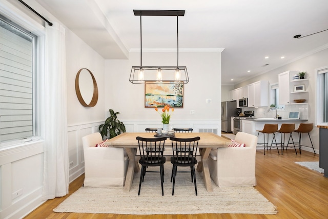 3316 N Leavitt St Unit 2, Chicago, IL 60618 - dining space with light wood-style floors, crown molding, wainscoting, a decorative wall, and recessed lighting
