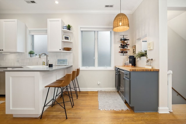 3316 N Leavitt St Unit 2, Chicago, IL 60618 - kitchen featuring a breakfast bar area, butcher block counters, light wood-type flooring, white cabinetry, and open shelves
