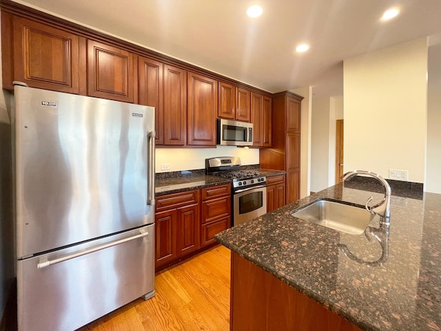 5064 W Agatite Ave Unit 3, Chicago, IL 60630 - kitchen with appliances with stainless steel finishes, light wood finished floors, dark stone countertops, recessed lighting, and a peninsula