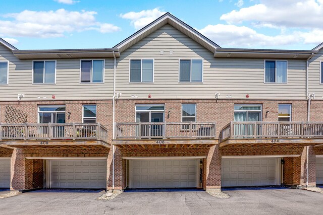 406 Prairie Ct, Morton Grove, IL 60053 - back of property featuring a garage, brick siding, and driveway