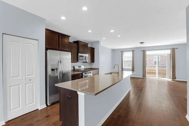 406 Prairie Ct, Morton Grove, IL 60053 - kitchen featuring appliances with stainless steel finishes, a kitchen island with sink, dark brown cabinets, dark wood finished floors, and recessed lighting