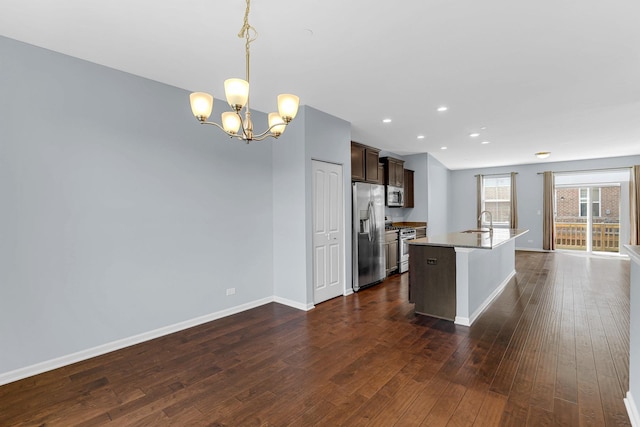 406 Prairie Ct, Morton Grove, IL 60053 - kitchen featuring stainless steel appliances, a chandelier, dark brown cabinetry, dark wood-type flooring, and an island with sink