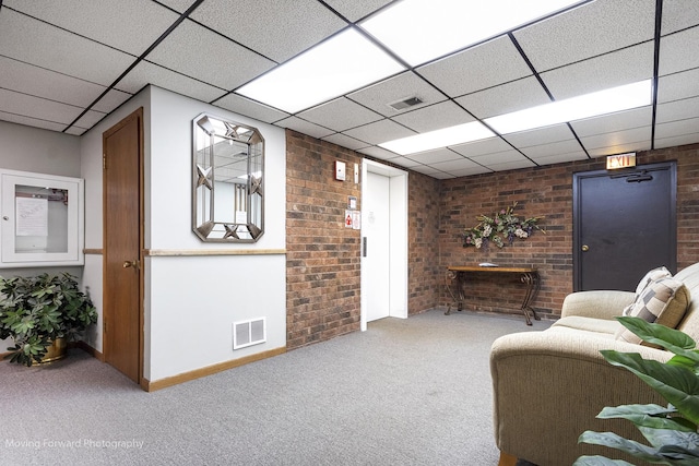1502 Woodbridge Rd Unit 2H, Joliet, IL 60436 - carpeted living room featuring brick wall and a paneled ceiling