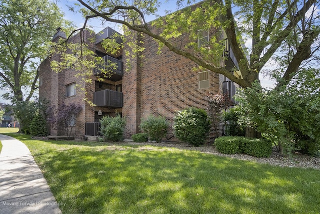 1502 Woodbridge Rd Unit 2H, Joliet, IL 60436 - view of side of property with a yard, brick siding, and a balcony
