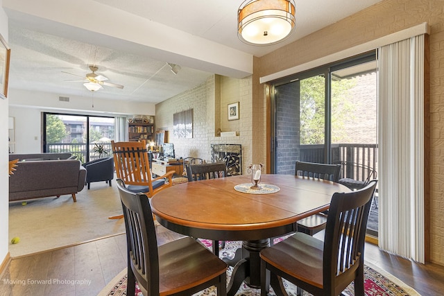 1502 Woodbridge Rd Unit 2H, Joliet, IL 60436 - dining area featuring a ceiling fan, wood finished floors, healthy amount of natural light, and brick wall