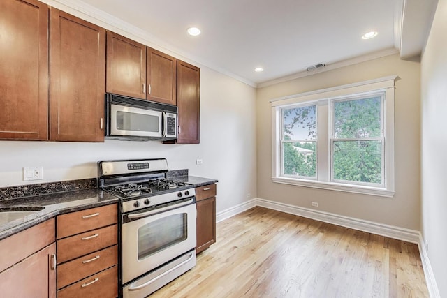 3851 N Kedvale Ave Unit E3, Chicago, IL 60641 - kitchen with appliances with stainless steel finishes, crown molding, dark stone counters, light wood-style flooring, and recessed lighting