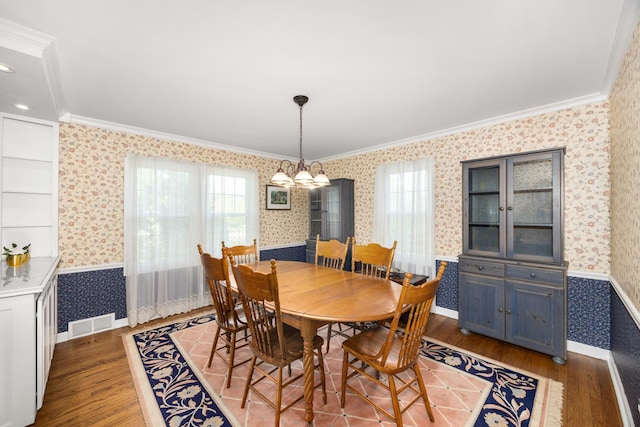 401 Greenwood Rd, Glenview, IL 60025 - dining space featuring wallpapered walls, ornamental molding, and wood finished floors