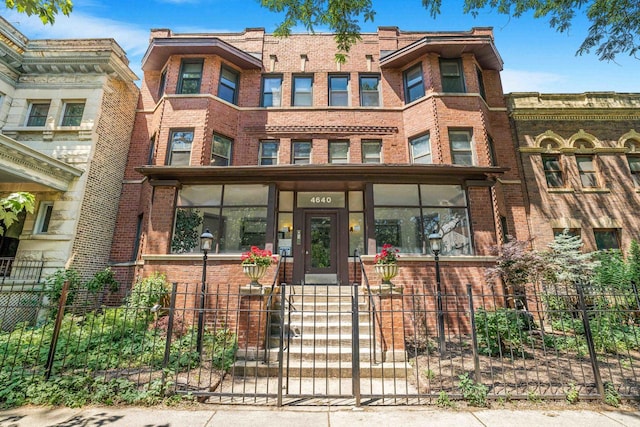 4640 N Kenmore Ave Unit 2S, Chicago, IL 60640 - view of front facade featuring brick siding and a fenced front yard