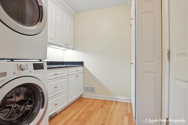 32756 N Stone Manor Dr, Grayslake, IL 60030 - washroom with stacked washer / dryer, cabinet space, and light wood-style floors