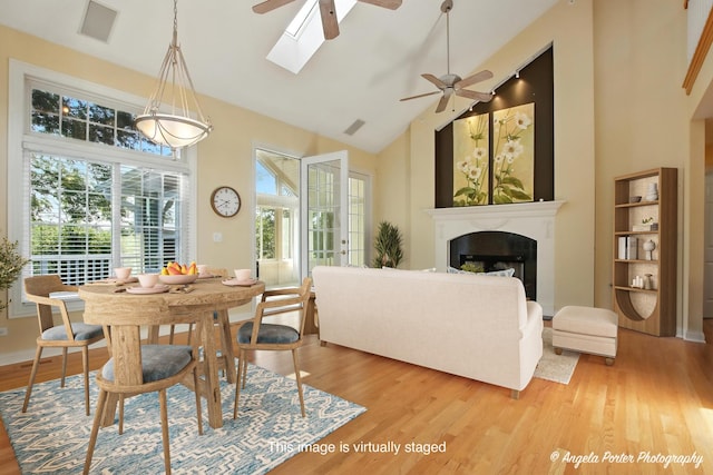 32756 N Stone Manor Dr, Grayslake, IL 60030 - dining room with ceiling fan, high vaulted ceiling, light wood finished floors, a fireplace, and a skylight