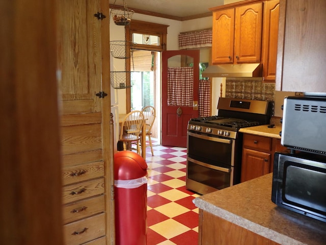 303 N Walnut St, Wenona, IL 61377 - kitchen with range with two ovens, under cabinet range hood, light flooring, ornamental molding, and decorative backsplash