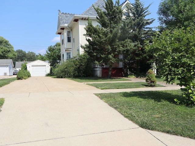 303 N Walnut St, Wenona, IL 61377 - view of front of house featuring driveway, a garage, a front lawn, and an outdoor structure