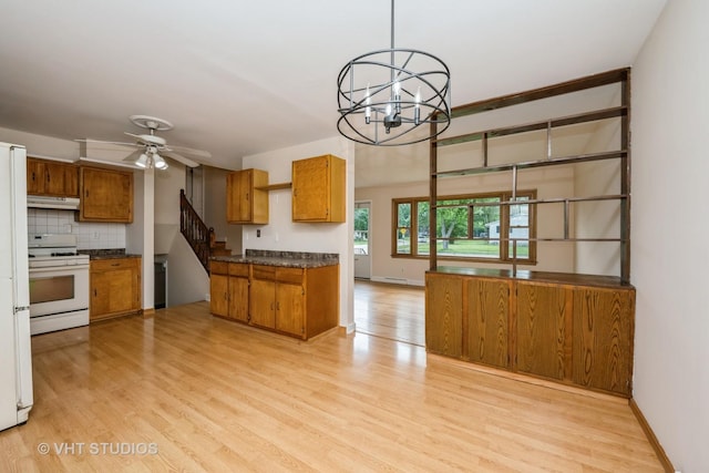 401 Elden Dr, Cary, IL 60013 - kitchen featuring white gas range, brown cabinets, dark countertops, and under cabinet range hood
