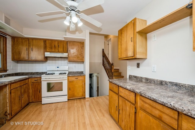 401 Elden Dr, Cary, IL 60013 - kitchen featuring white gas range oven, light wood-style flooring, brown cabinetry, and under cabinet range hood