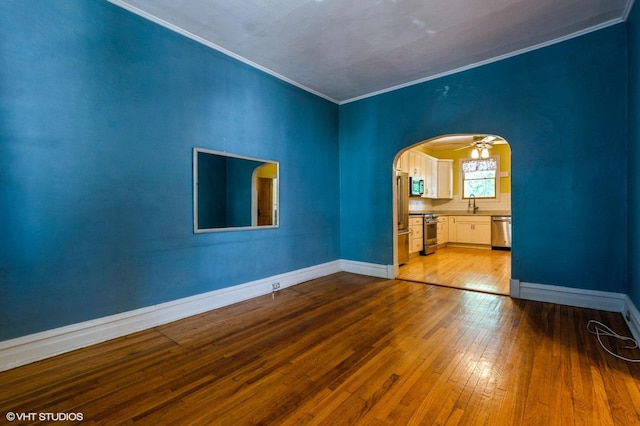 2721 W Prindiville St, Chicago, IL 60647 - empty room featuring crown molding, hardwood / wood-style flooring, and arched walkways