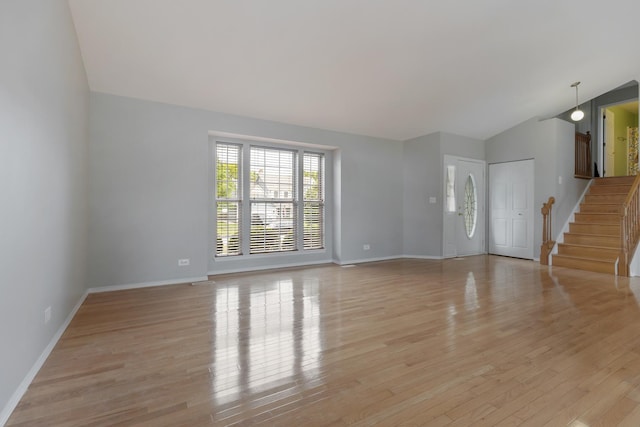 395 Wildberry Ln, Bartlett, IL 60103 - unfurnished living room featuring vaulted ceiling, light wood finished floors, and stairs