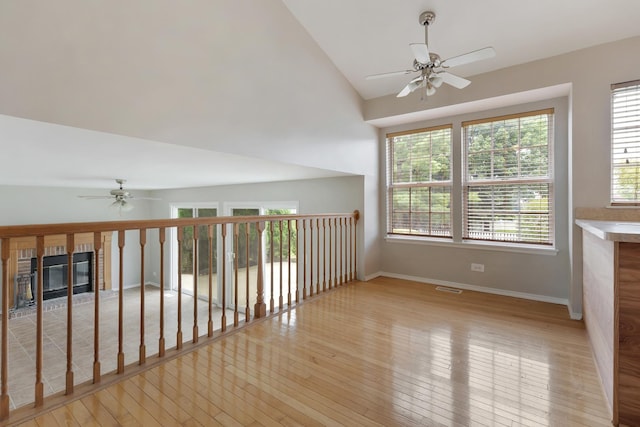 395 Wildberry Ln, Bartlett, IL 60103 - empty room featuring ceiling fan, a glass covered fireplace, light wood finished floors, and lofted ceiling