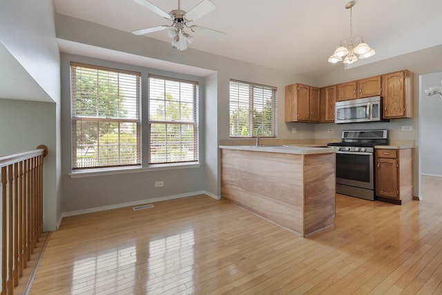 395 Wildberry Ln, Bartlett, IL 60103 - kitchen featuring stainless steel appliances, light countertops, light wood-type flooring, a chandelier, and decorative light fixtures