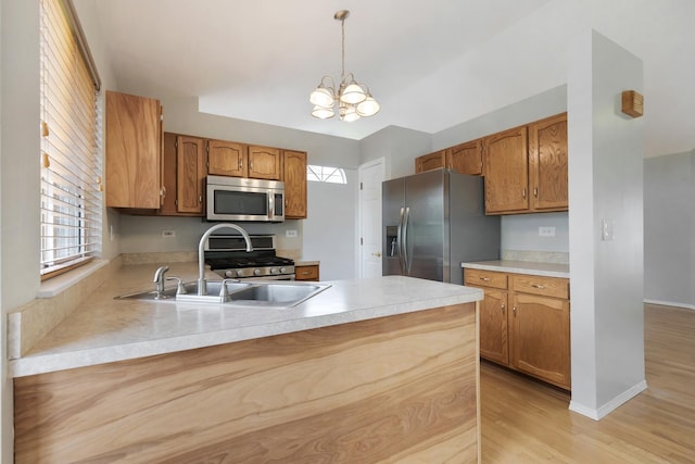 395 Wildberry Ln, Bartlett, IL 60103 - kitchen featuring appliances with stainless steel finishes, a peninsula, a chandelier, light countertops, and light wood finished floors