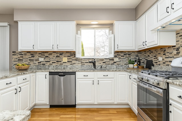 1008 Lakewood Cir, Naperville, IL 60540 - kitchen with stainless steel appliances, under cabinet range hood, light wood-type flooring, and white cabinetry