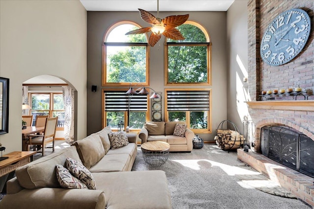 531 Danbury Dr, Oswego, IL 60543 - living area featuring a towering ceiling, arched walkways, carpet, and a brick fireplace
