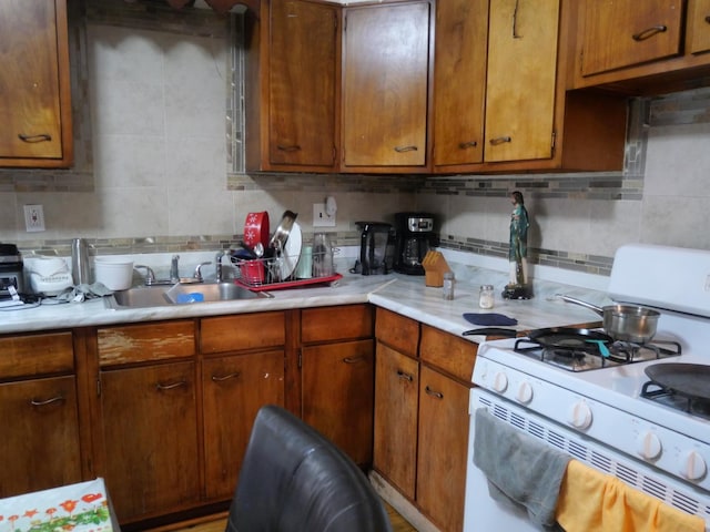 4417 S Campbell Ave, Chicago, IL 60632 - kitchen featuring white gas range, light countertops, backsplash, and brown cabinetry
