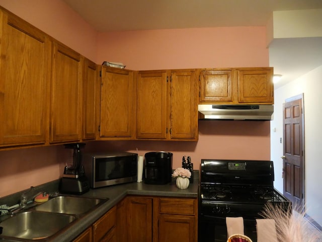 4417 S Campbell Ave, Chicago, IL 60632 - kitchen with gas stove, under cabinet range hood, stainless steel microwave, brown cabinetry, and dark countertops