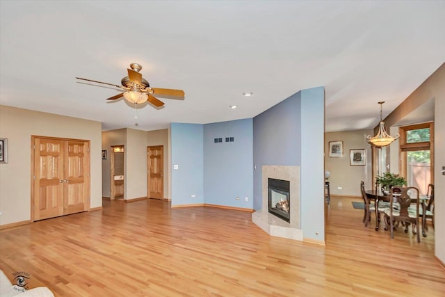 10754 Canterbury Dr, Mokena, IL 60448 - unfurnished living room featuring light wood-style floors, ceiling fan, and a premium fireplace