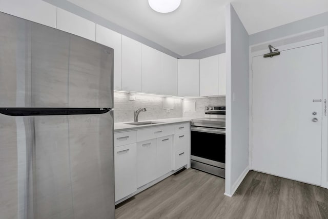 3600 N Lake Shore Dr Unit 1004, Chicago, IL 60613 - kitchen featuring appliances with stainless steel finishes, light wood-style floors, backsplash, white cabinetry, and light countertops