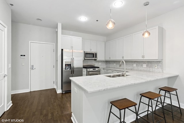 150 W Superior St Unit 605, Chicago, IL 60654 - kitchen featuring appliances with stainless steel finishes, a peninsula, tasteful backsplash, and dark wood finished floors